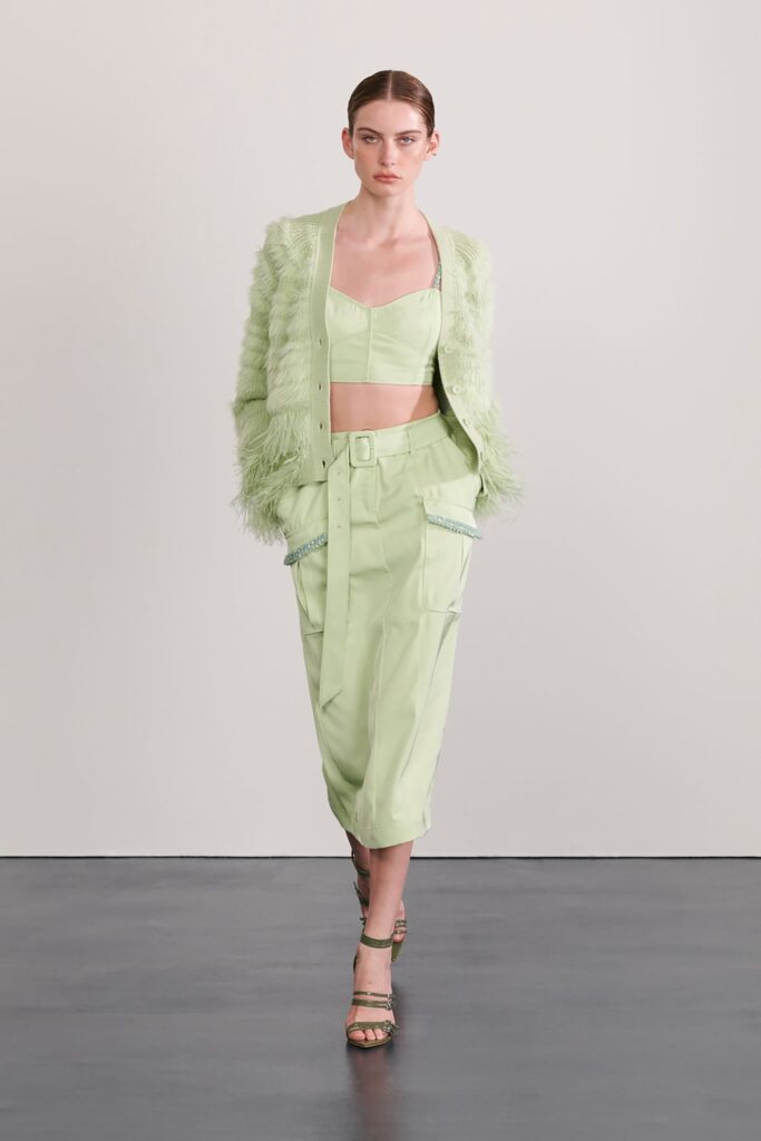 A fitted green sleeveless top paired with pleated pants featuring a collared design.