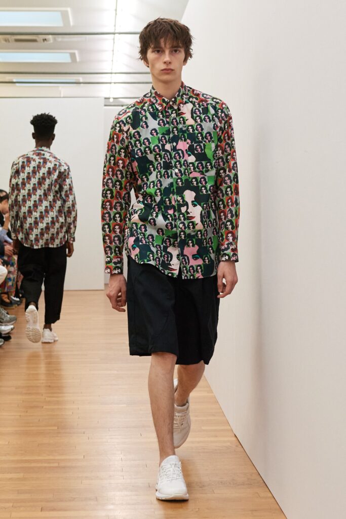 A relaxed fit multicolor printed shirt with short sleeves paired with casual shorts.