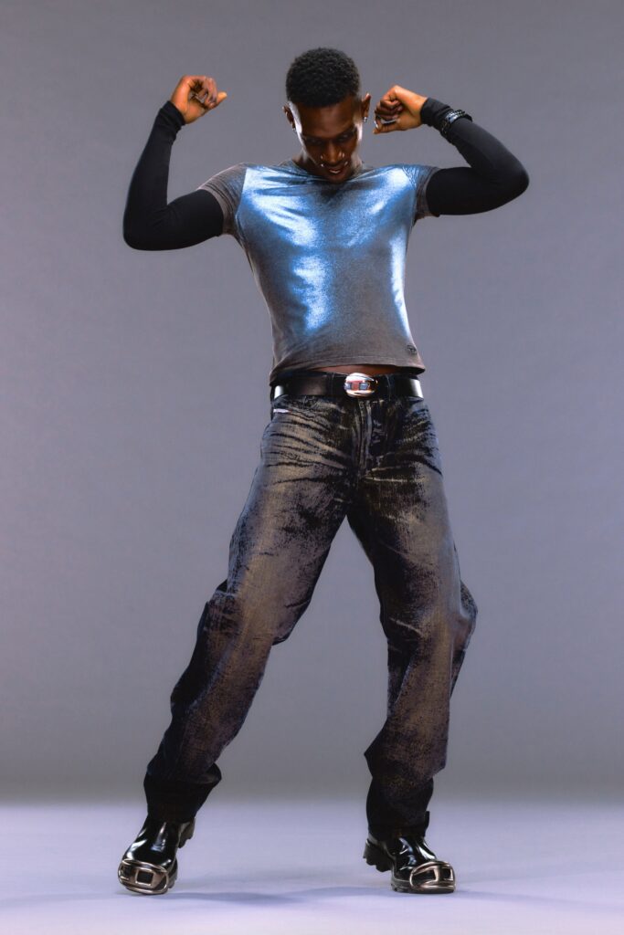 A fitted blue top with long sleeves paired with straight-leg black denim pants.
