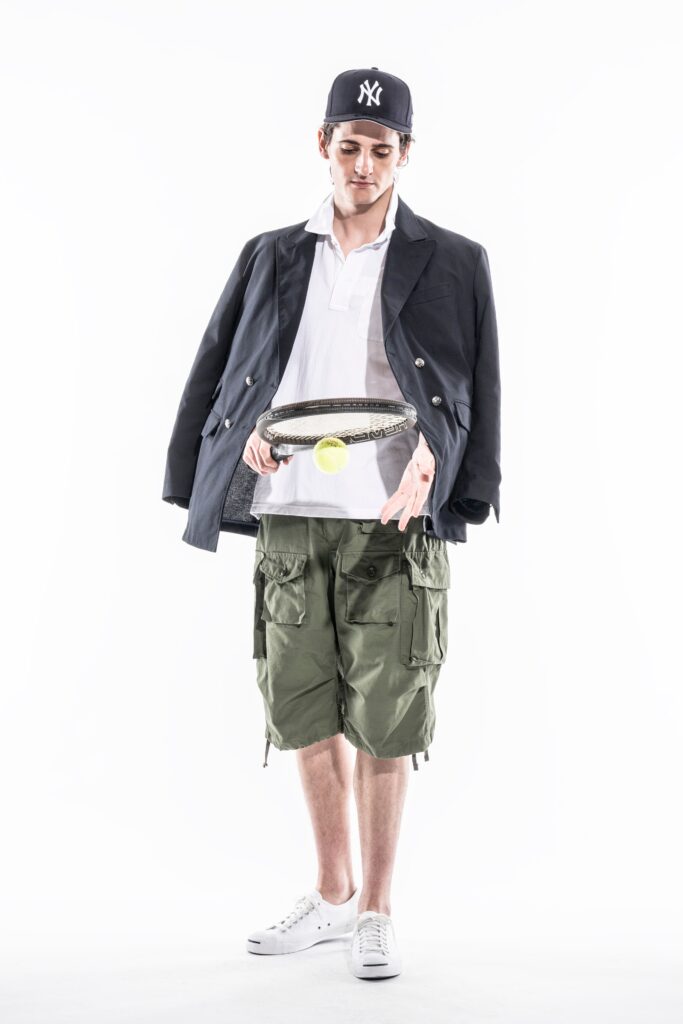 A relaxed black jacket paired with green cargo shorts, featuring a collared shirt underneath.