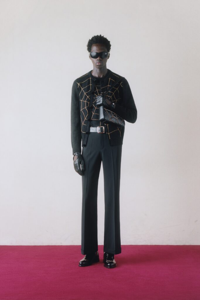 A fitted black cotton jacket with long sleeves and collared design paired with straight-leg pants.