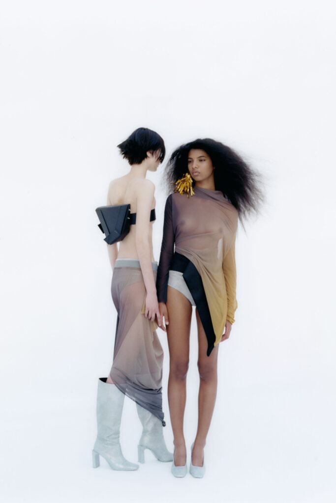 A fitted silk dress featuring an asymmetric design and layered elements in black and beige.