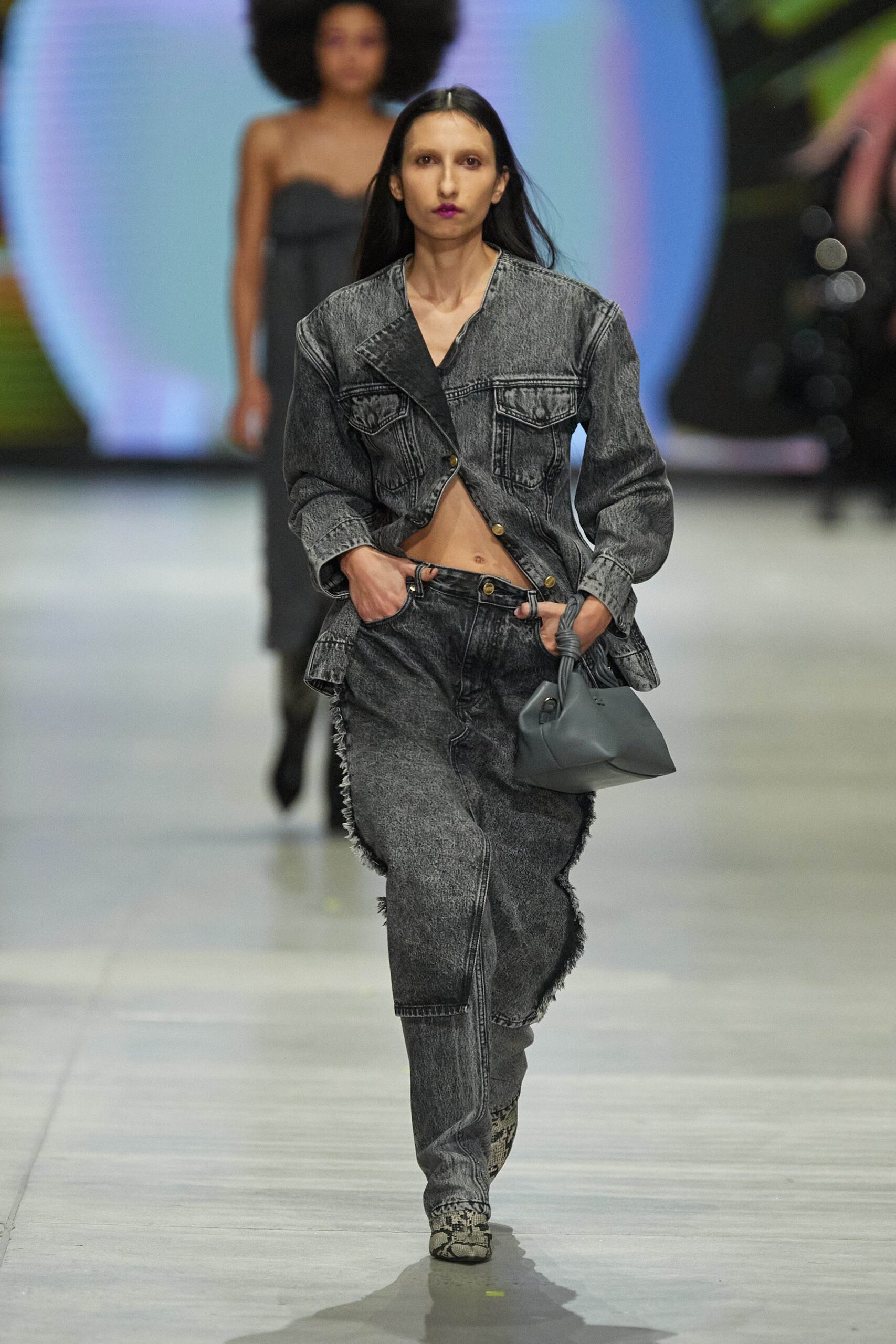 A relaxed gray denim jacket with long sleeves and fringed pants, featuring a collared design.