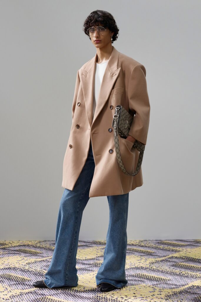 A relaxed beige jacket with a collared neckline paired with wide-leg blue denim pants.