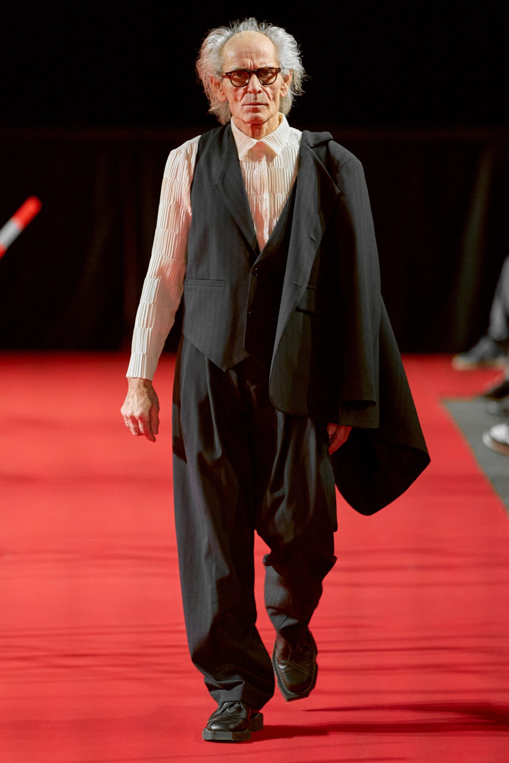 A relaxed black suit featuring a vest and long-sleeve collared shirt.