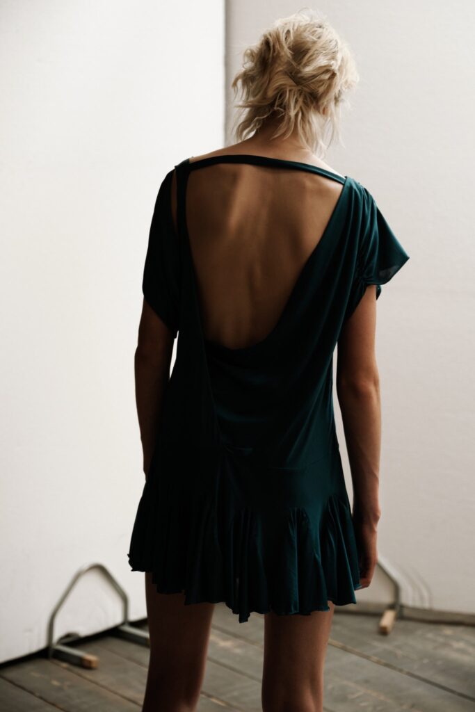 A relaxed green silk sleeveless dress featuring a backless design and flared silhouette.