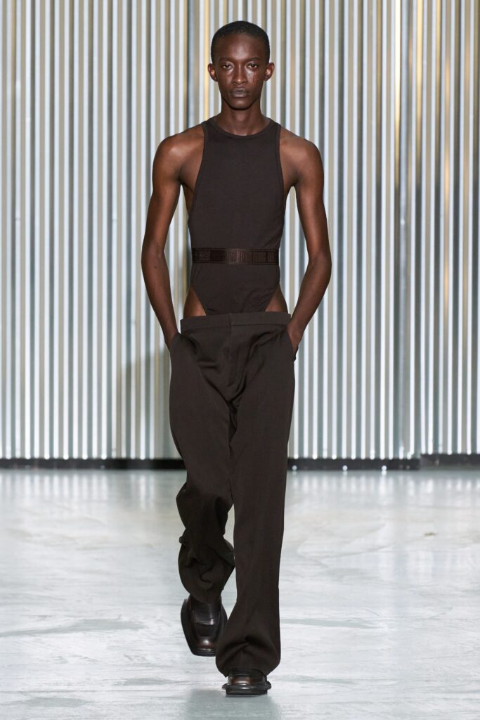A fitted black sleeveless bodysuit paired with straight-leg pants for a sleek look.