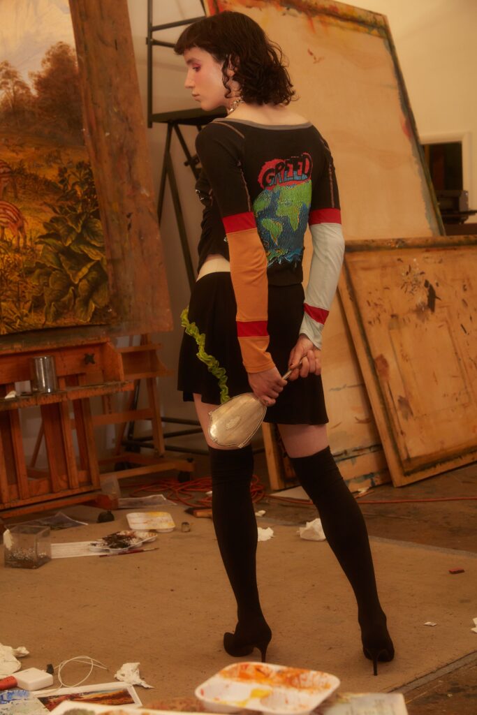 A fitted black and multicolor dress layered over a long-sleeve top with an asymmetric design.
