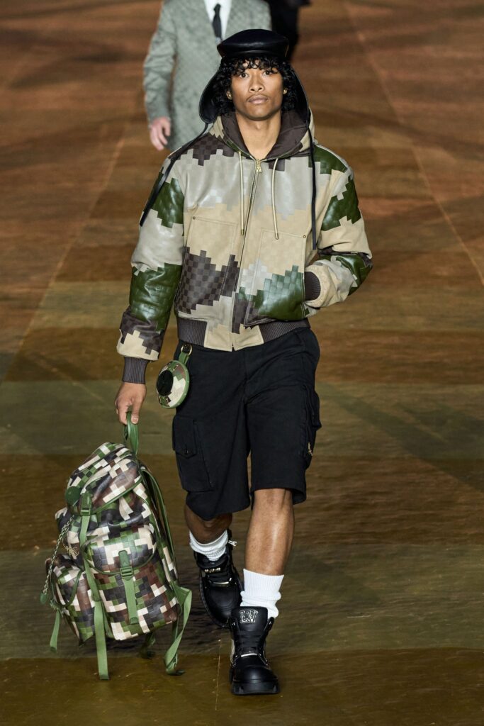 A relaxed fit green camouflage jacket paired with black shorts for a stylish streetwear look.