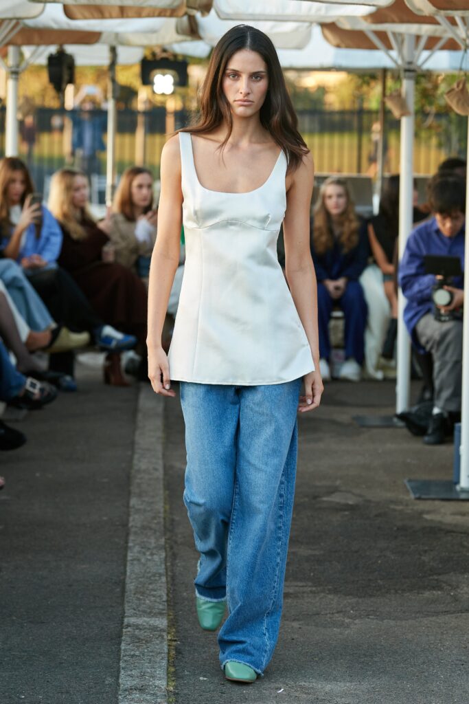 A relaxed white sleeveless top paired with wide-leg blue pants for a casual look.