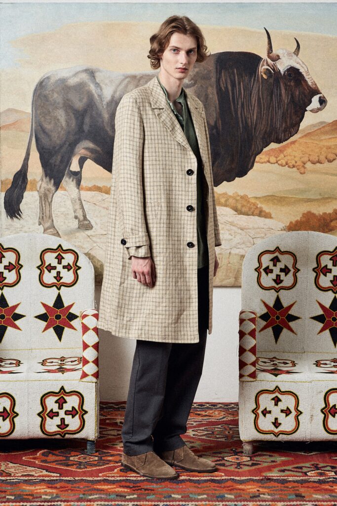 A relaxed beige checked coat paired with gray pants, featuring a collared design.
