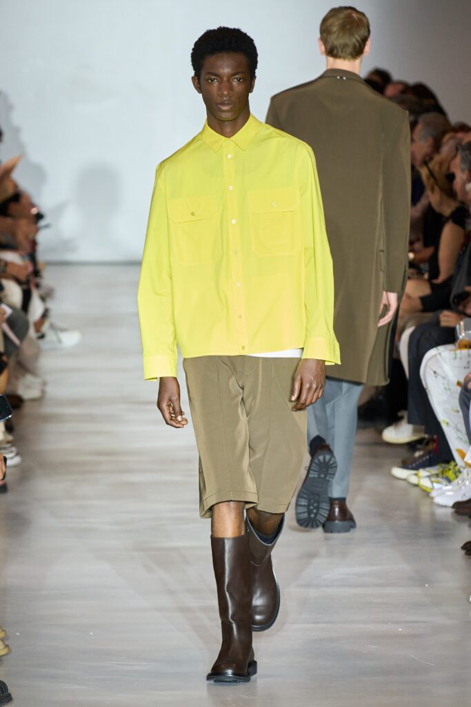 A relaxed yellow cotton short-sleeve shirt paired with brown shorts, featuring a buttoned design.