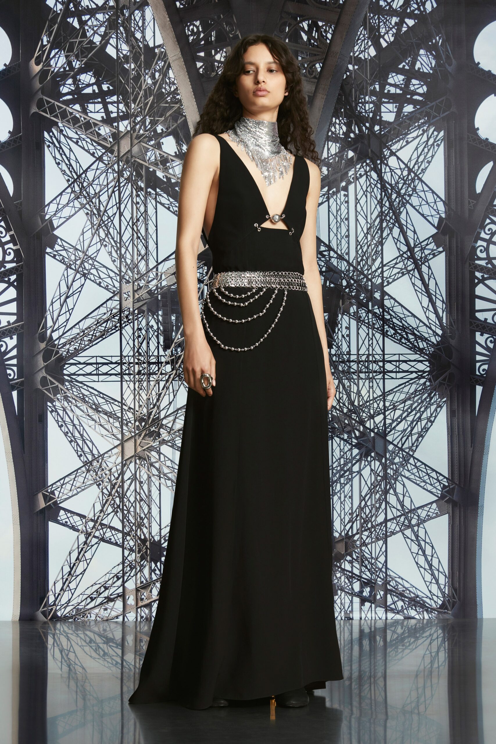 A fitted black silk dress with a sleeveless design and V-neckline, featuring a flowing silhouette.