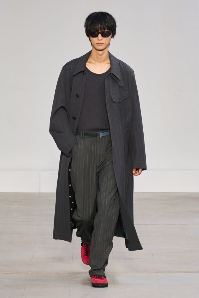 A relaxed black striped coat paired with gray pants for a contemporary look.