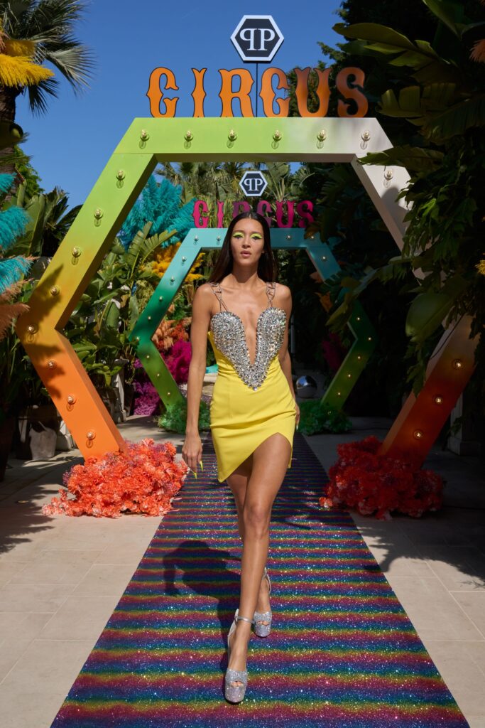 A fitted yellow silk dress with a V-neckline and asymmetric design detail.