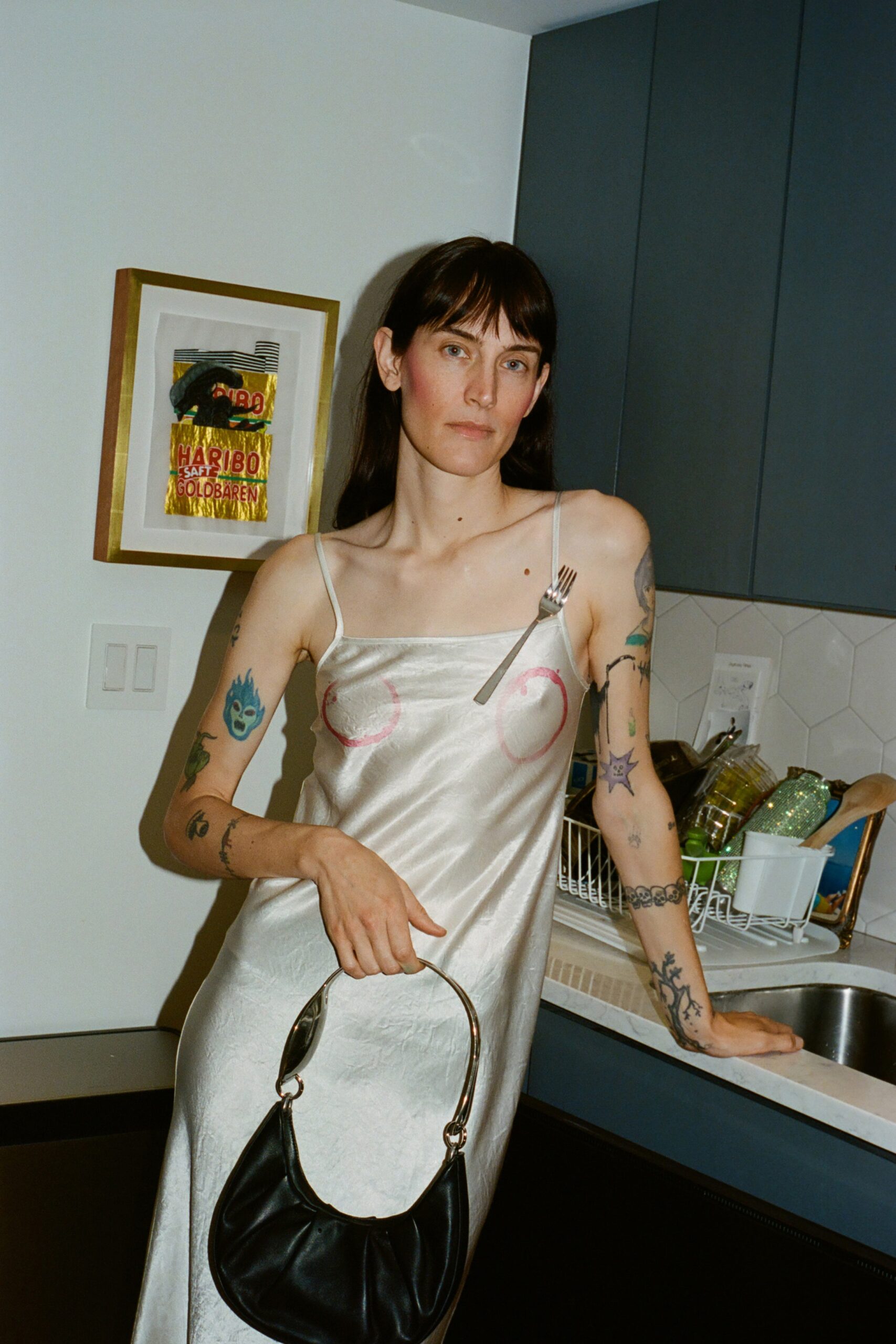 A fitted silver silk sleeveless dress with a V-neckline and asymmetric design detail.
