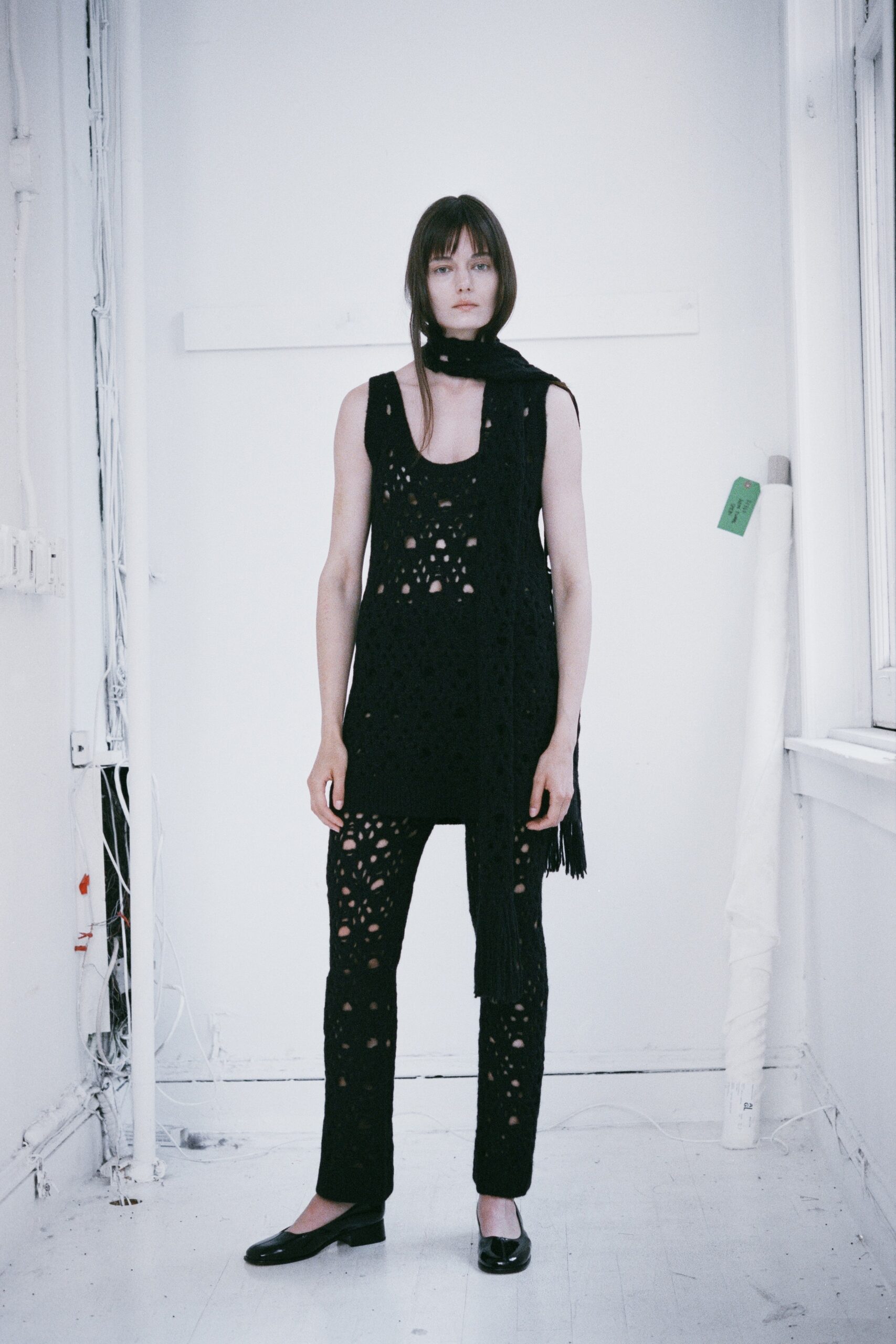 A fitted black sleeveless top with cutouts paired with matching fitted pants.