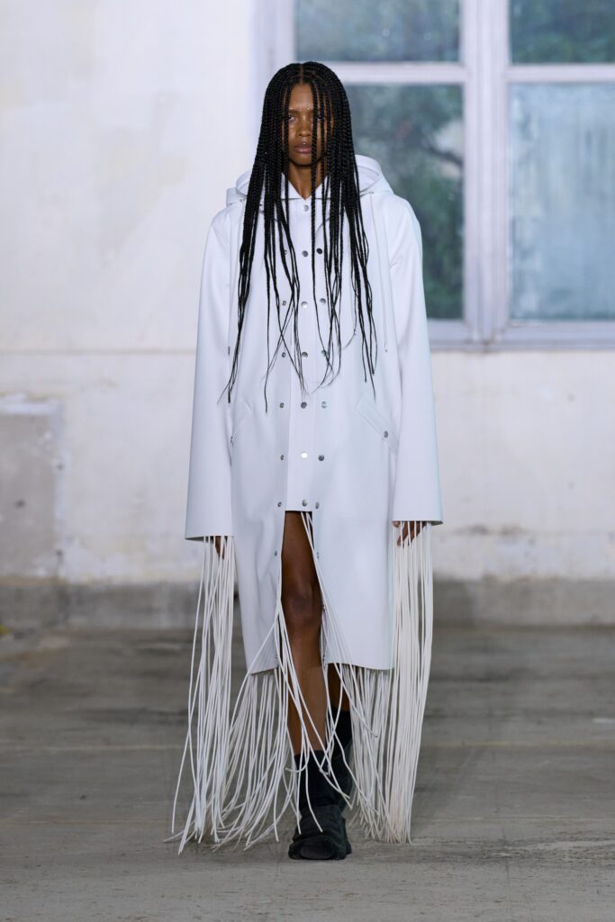 A relaxed white leather hooded coat with long sleeves and fringed detailing.