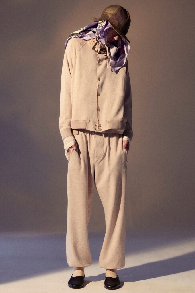 A relaxed beige cotton jacket with long sleeves and matching pants, featuring a buttoned design.