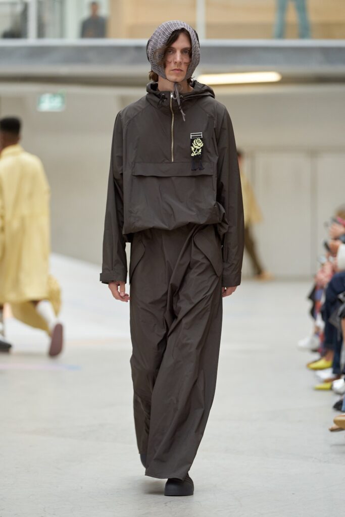 A relaxed brown cotton hooded jacket paired with matching relaxed pants, featuring a zippered detail.