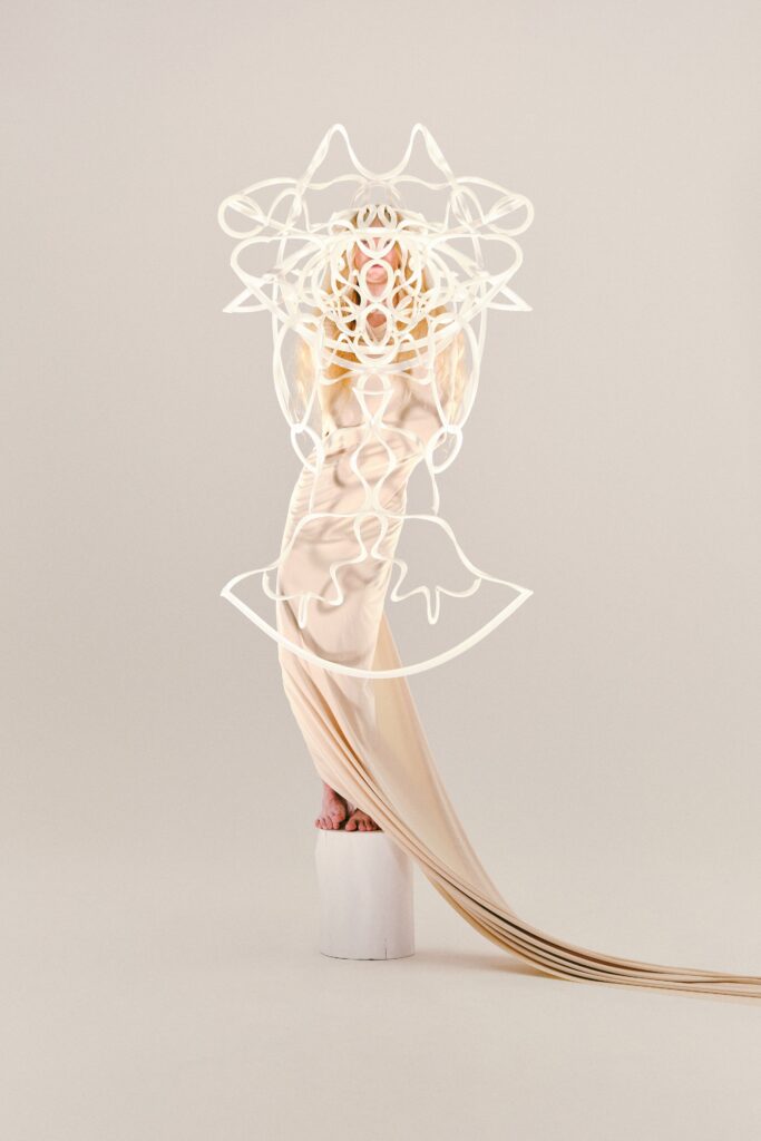 A draped beige silk gown with a longline silhouette and intricate design details.