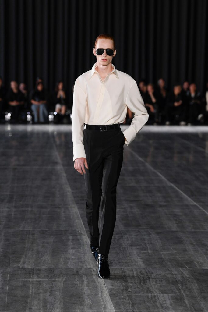 A fitted white long-sleeve collared shirt paired with straight-leg black pants.