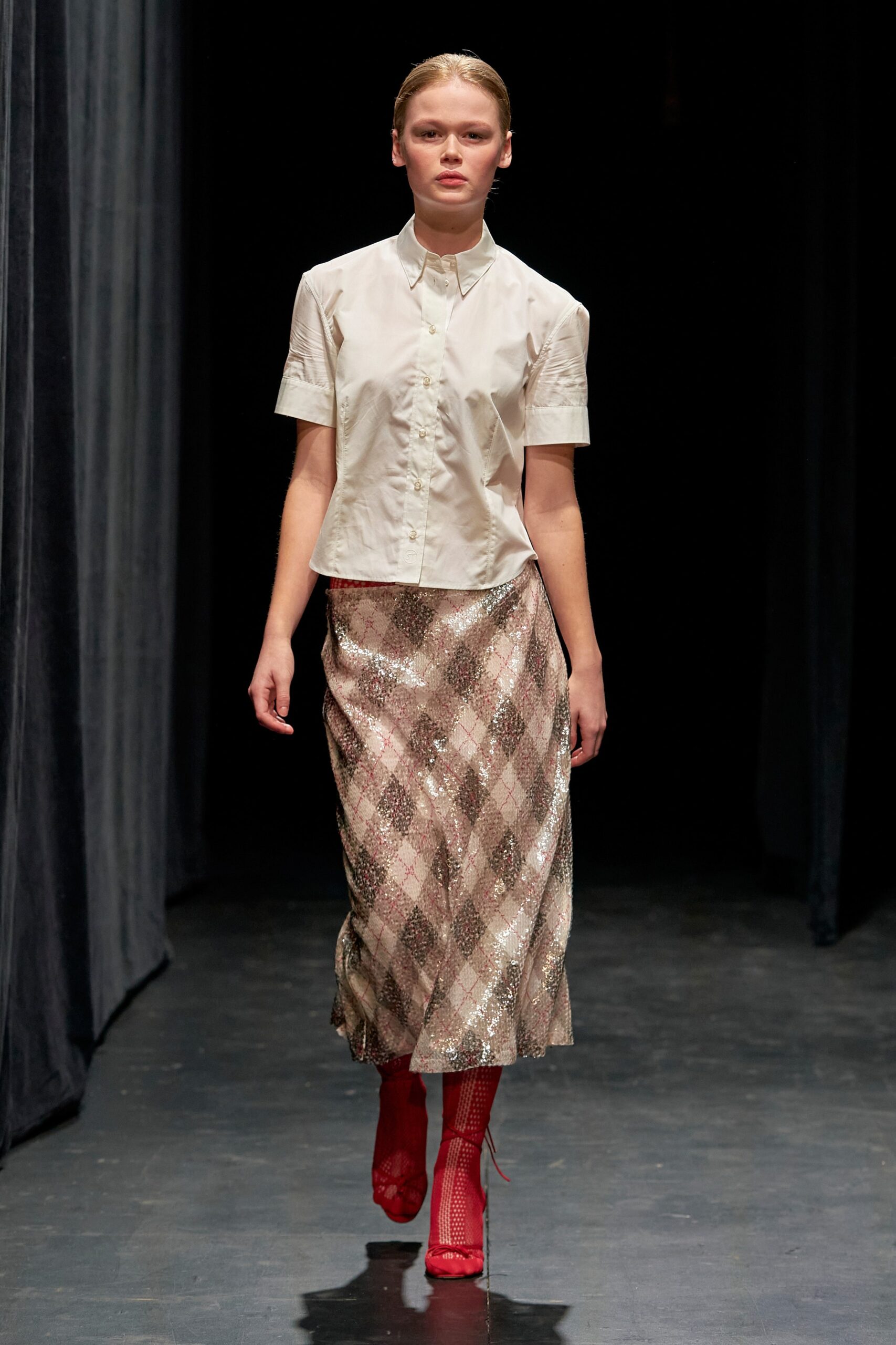 A fitted white short-sleeve shirt paired with a pleated pink sequin skirt.