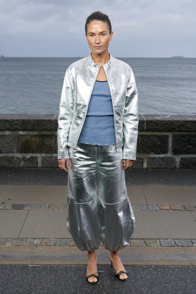 A relaxed silver metallic jacket with long sleeves paired with matching relaxed pants featuring a zippered detail.