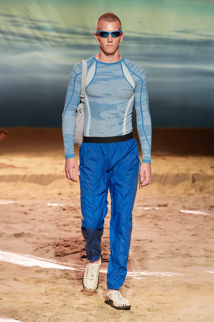 A fitted blue long-sleeve top with printed details paired with matching blue pants.