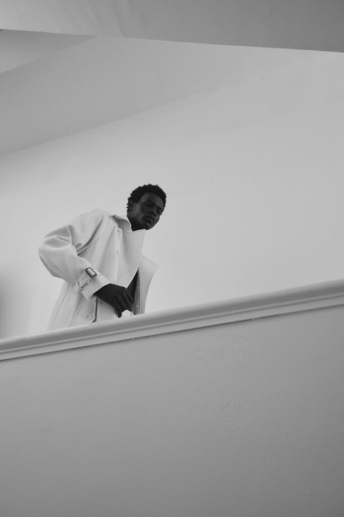 A relaxed white cotton coat with long sleeves and a collared design, featuring button details.