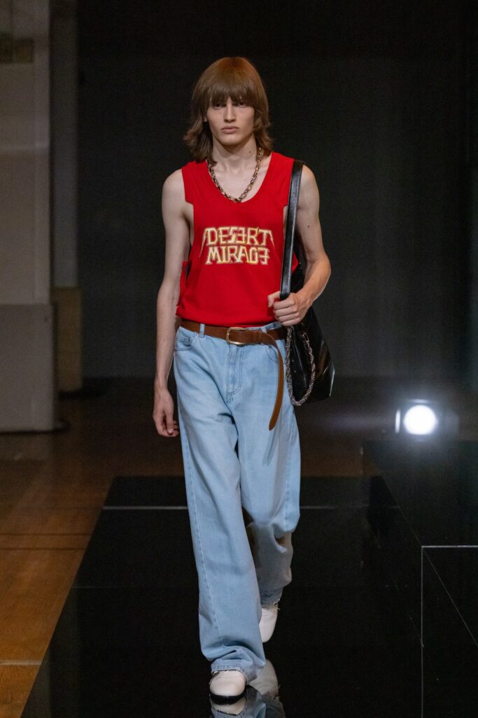 A relaxed red printed tank-top paired with wide-leg blue denim pants.