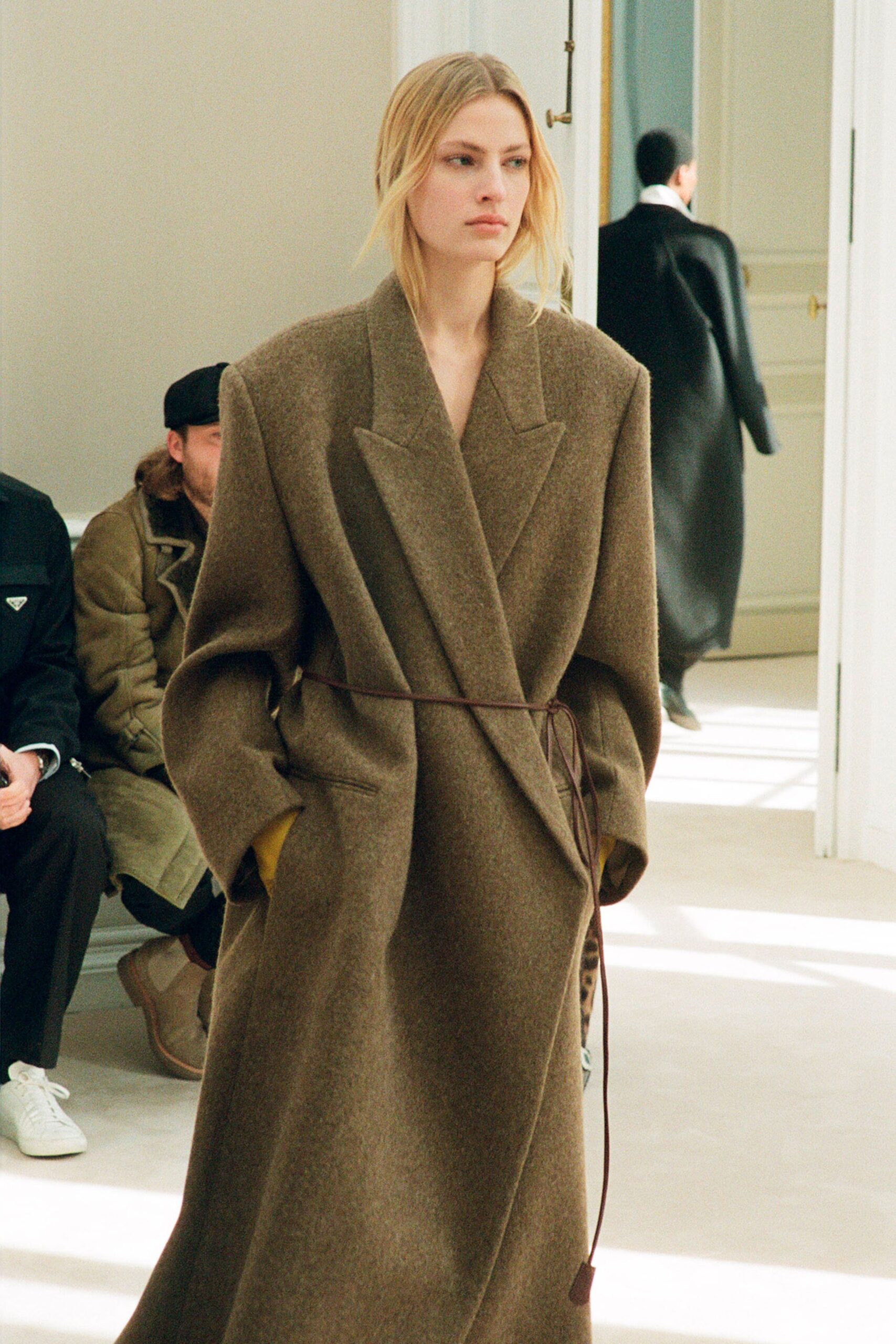 An oversized brown wool coat with long sleeves and a belted design.