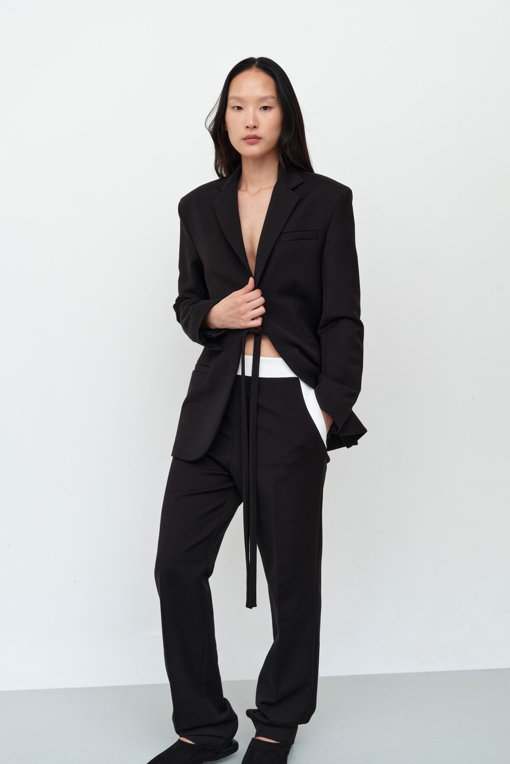 A relaxed black blazer with long sleeves and wide-leg pants, featuring a collared design.