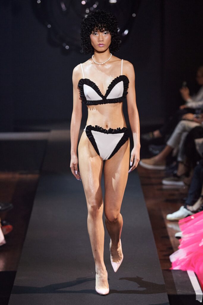 A fitted black and white bikini with ruffled details and a low-cut design.