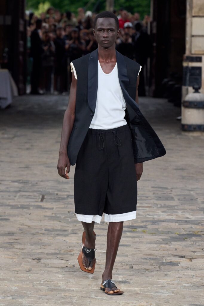 A relaxed black jacket with a collared design paired with white shorts.