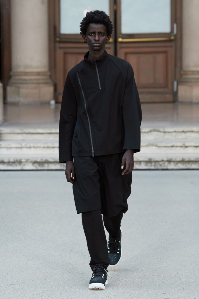 A relaxed black jacket with long sleeves and a zippered detail, paired with matching pants.