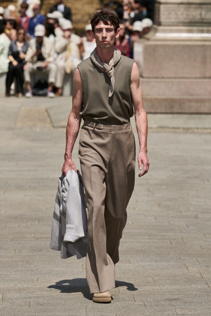 A relaxed beige cotton sleeveless top paired with wide-leg gray pants.