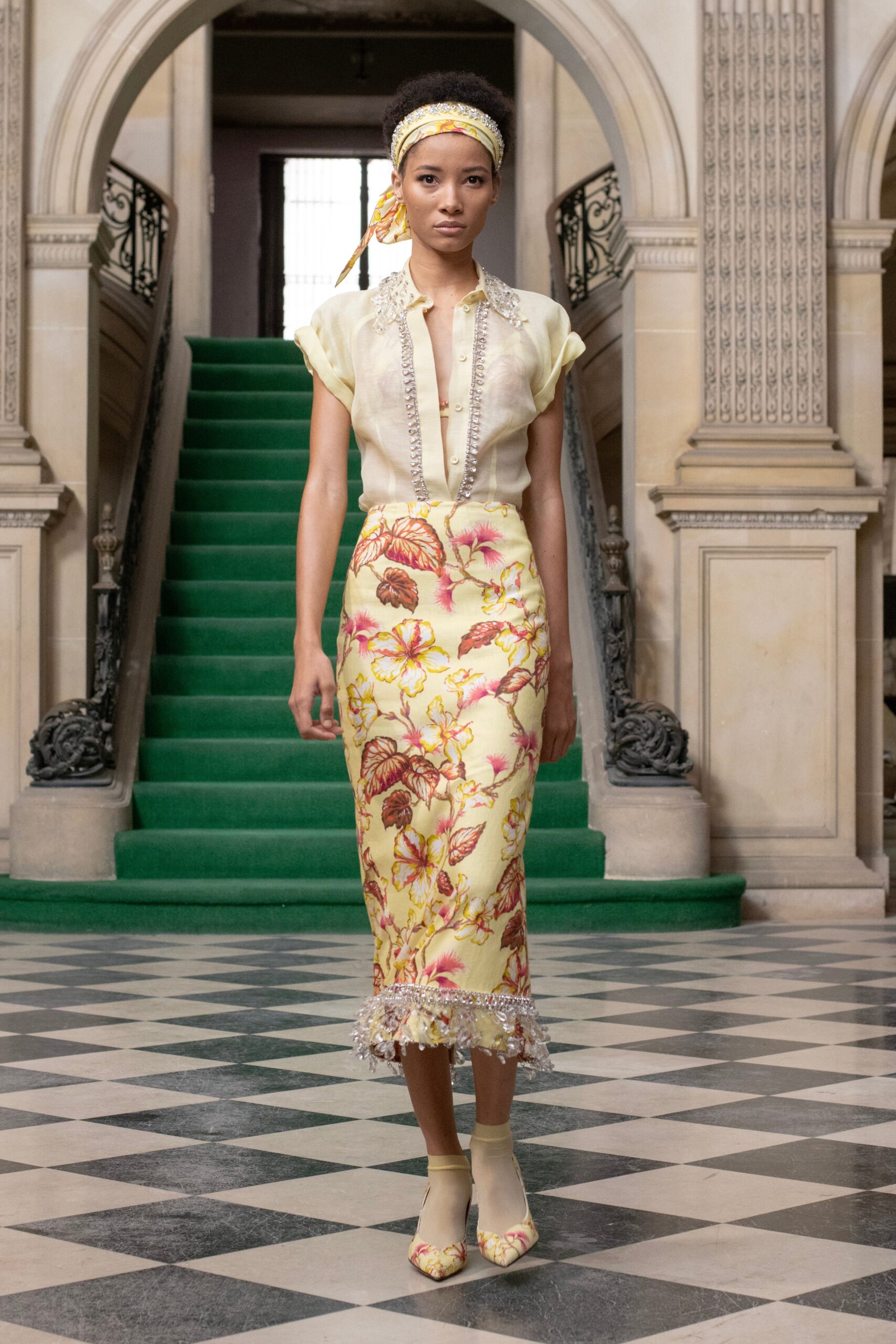 A fitted yellow floral blouse with a collared neckline paired with a pencil skirt.