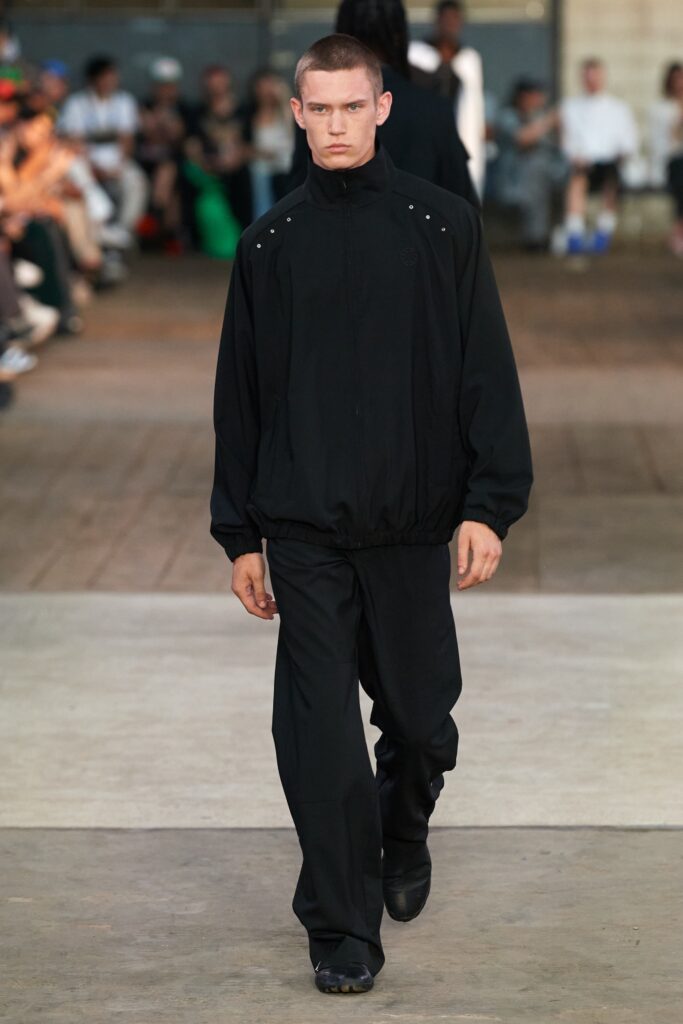 A relaxed black jacket with long sleeves and matching pants, featuring a zippered detail.
