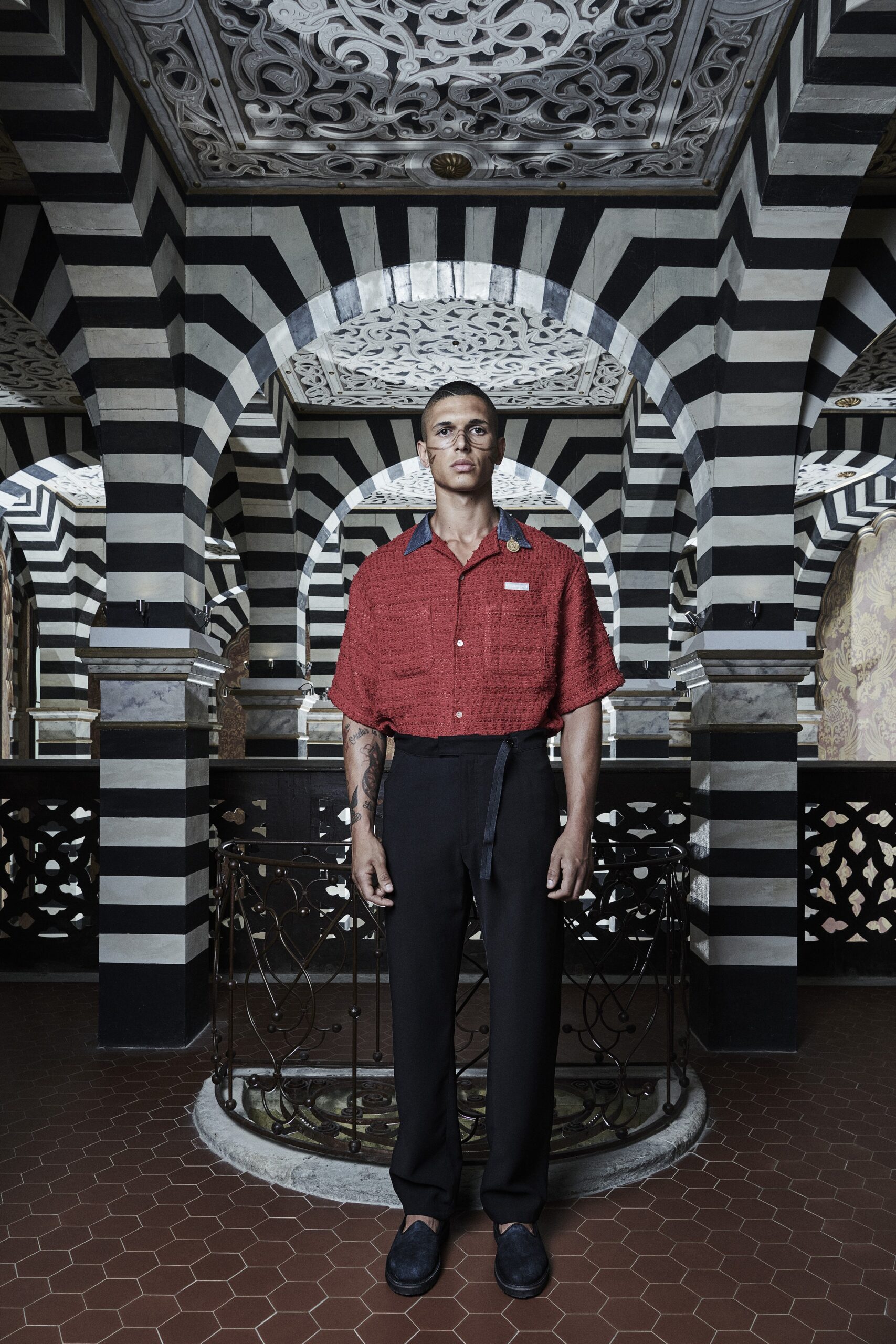 A relaxed red cotton short-sleeve shirt with a collared neckline and striped design.