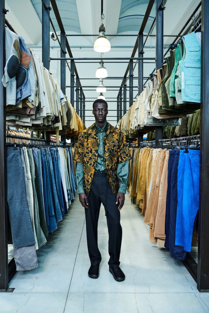 A fitted multicolor printed jacket with long sleeves paired with black fitted pants.