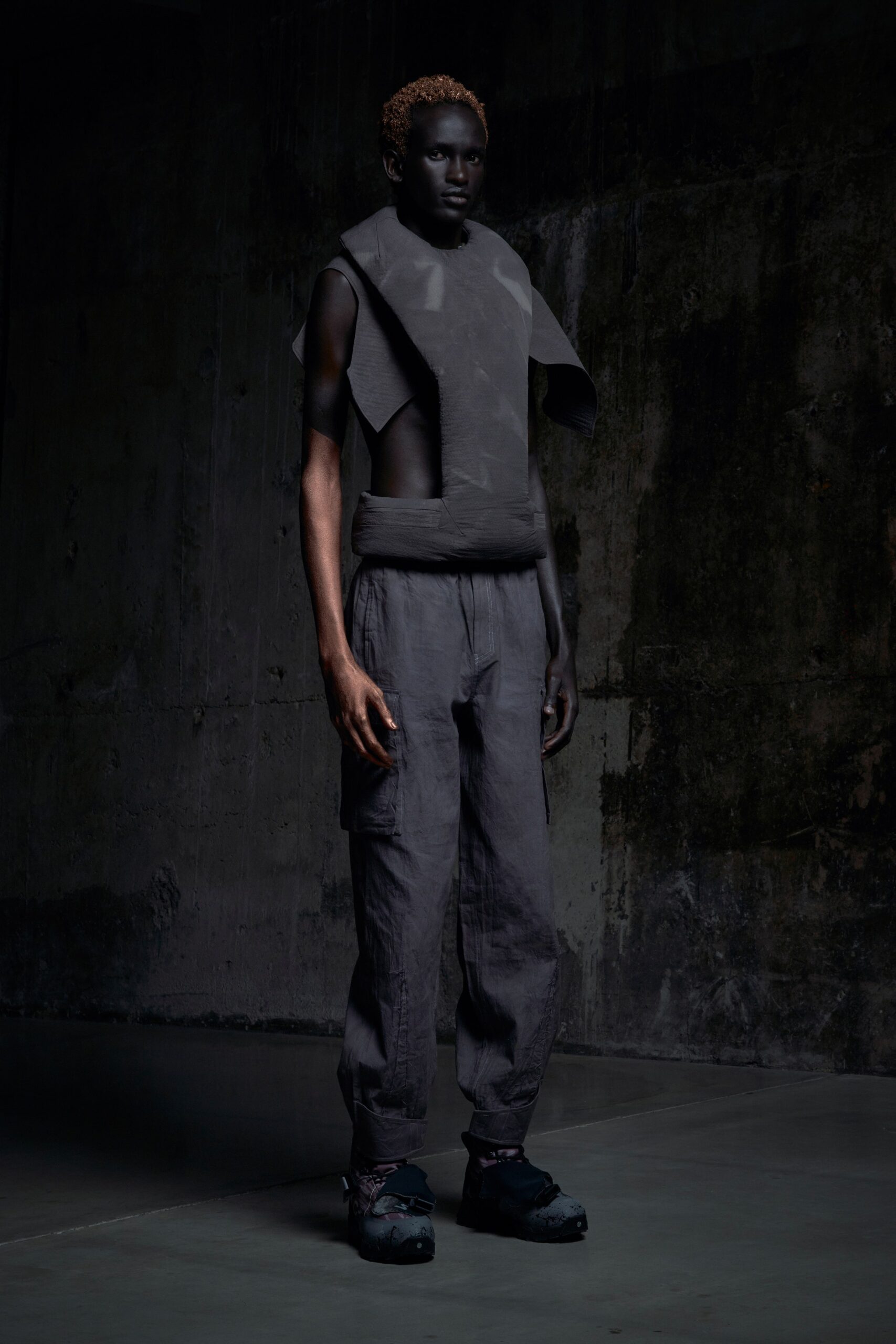 A relaxed black sleeveless top with a high-neck and asymmetric design paired with matching pants.