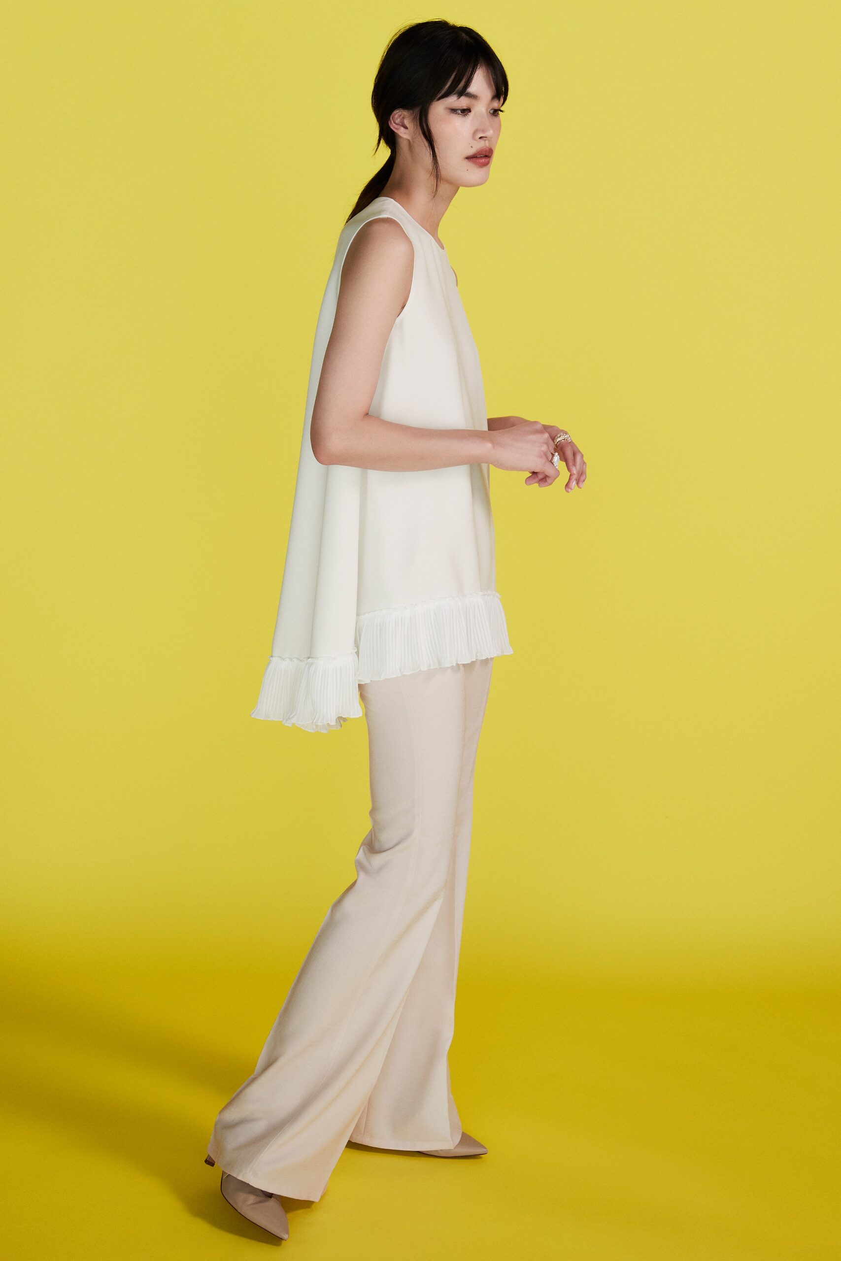 white relaxed top with fringes and beige flared pants