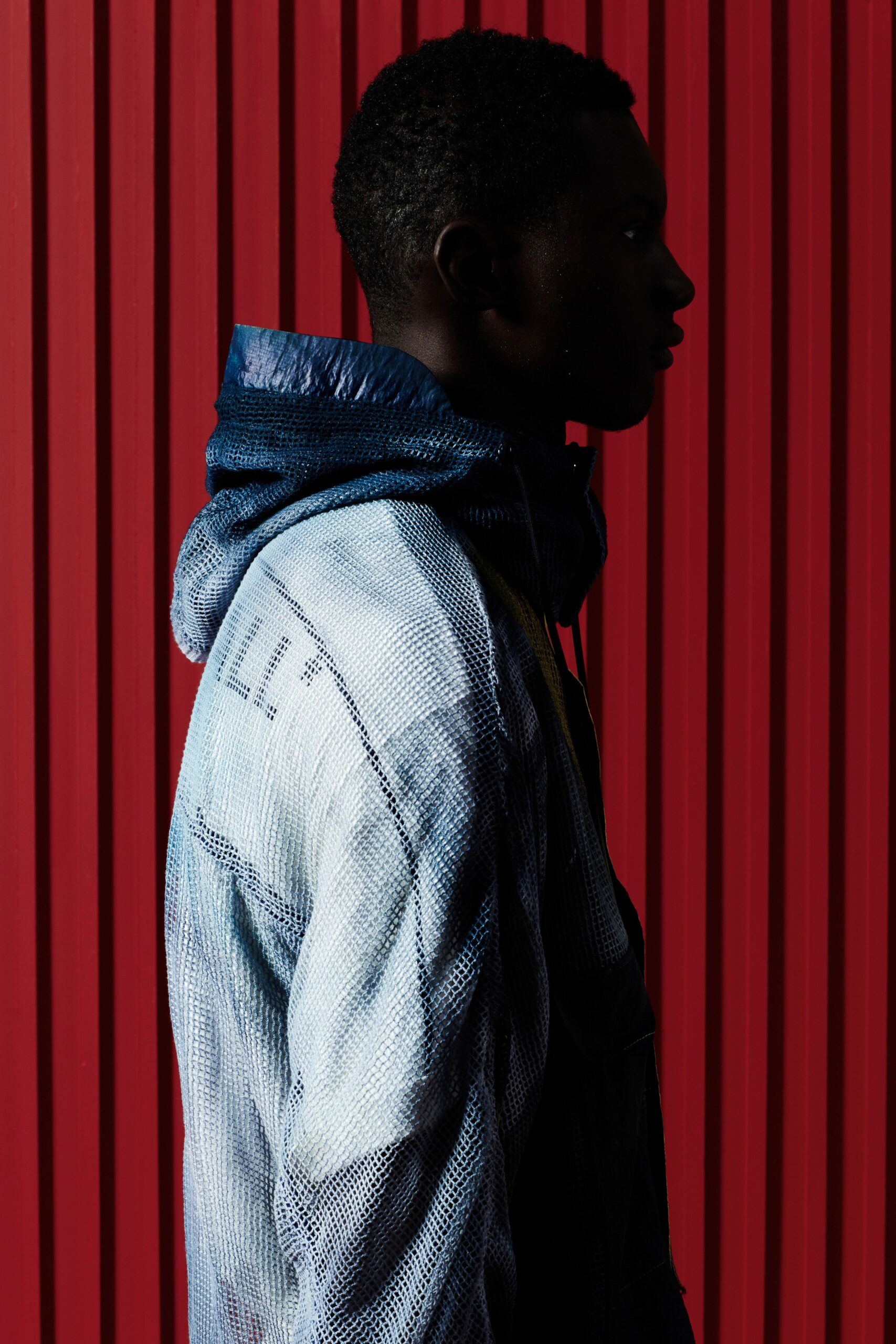 A relaxed blue denim hooded jacket with an asymmetric design detail.
