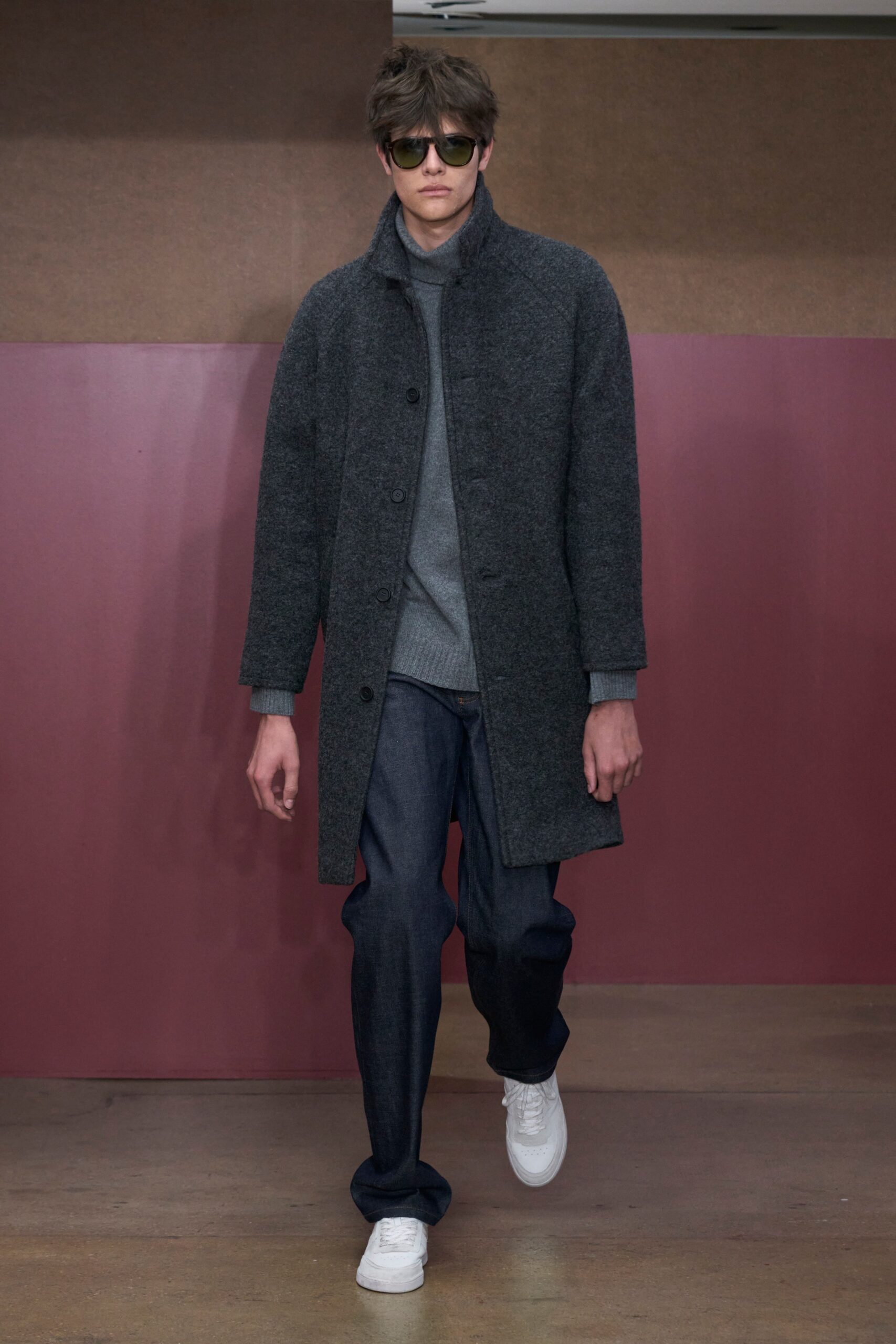 A relaxed gray wool coat layered over a blue sweater and straight-leg denim pants.