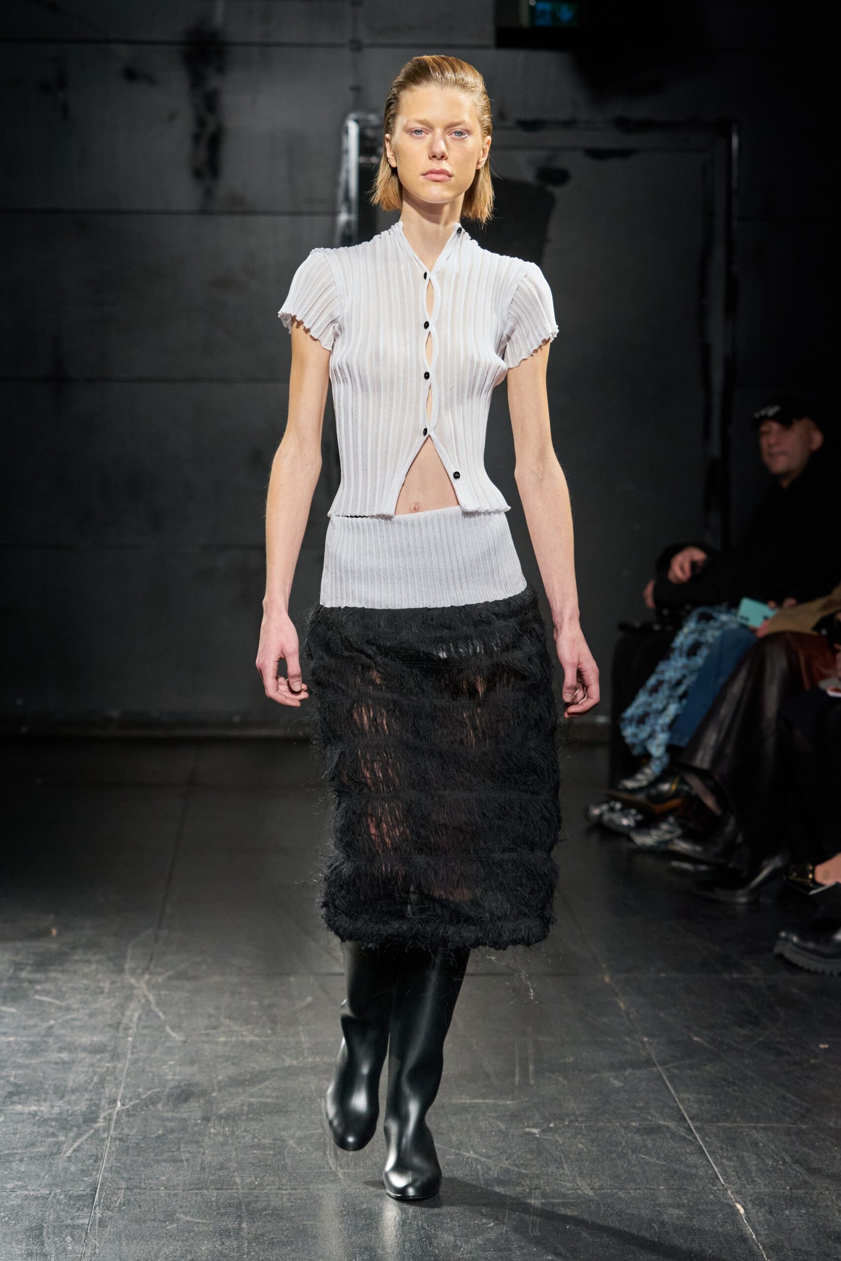 A fitted white short-sleeve top with a V-neck and a layered black skirt.