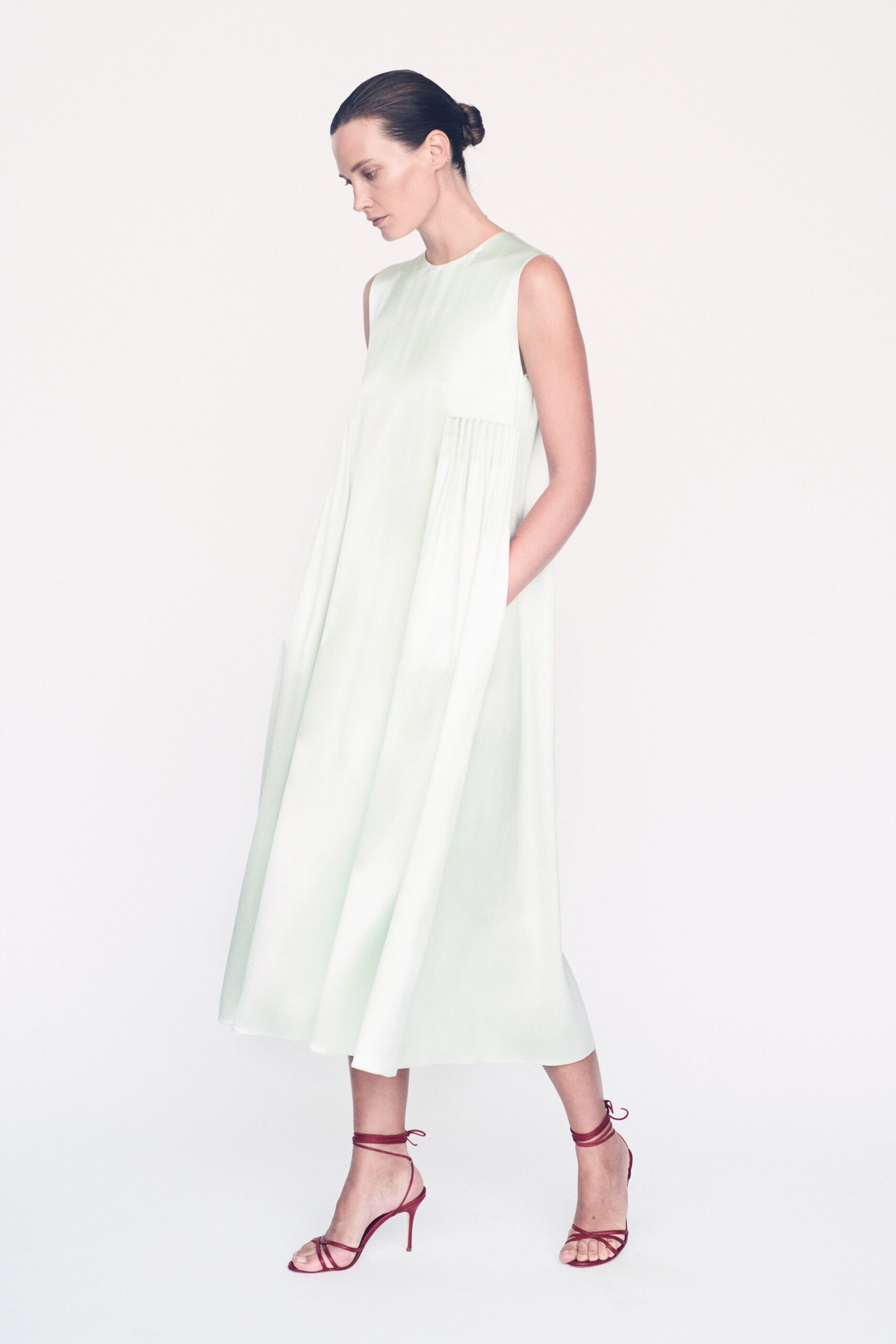green silk sleeveless high-neck relaxed pleated flowing dress