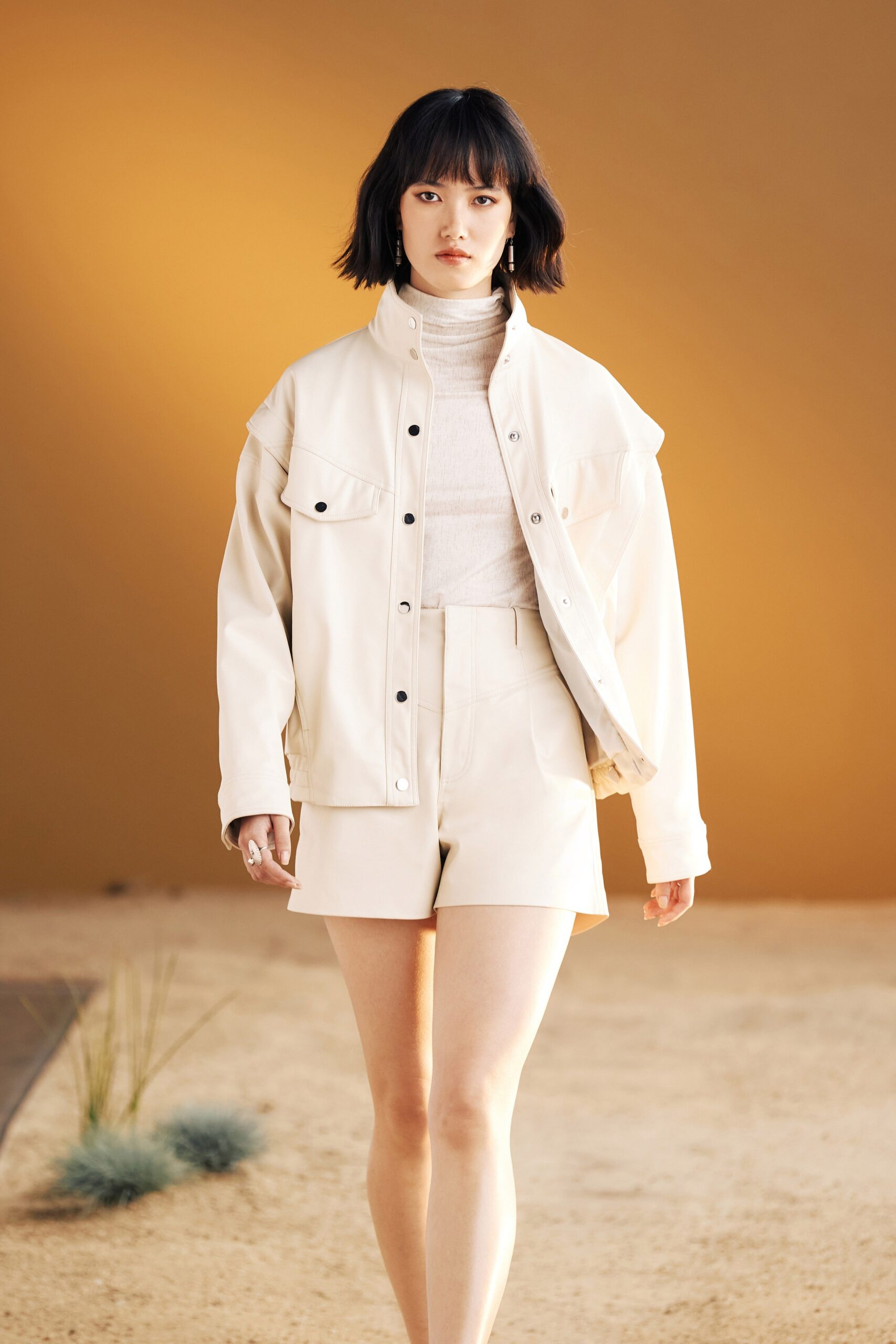 white leather jacket with beige top