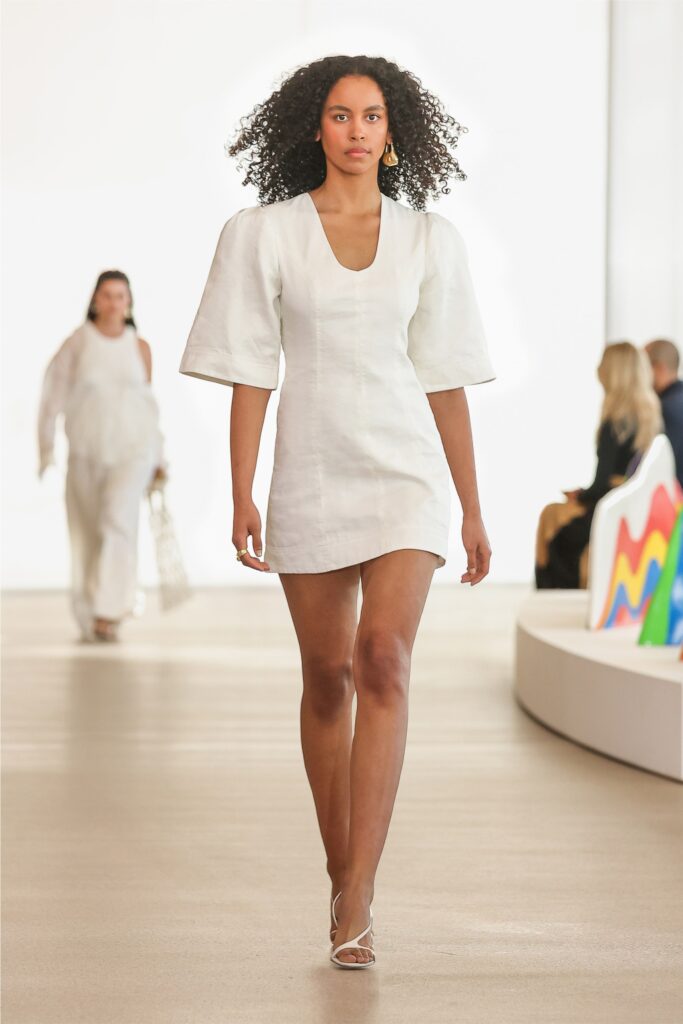 A fitted white mini dress with a V-neckline and short sleeves, perfect for summer outings.