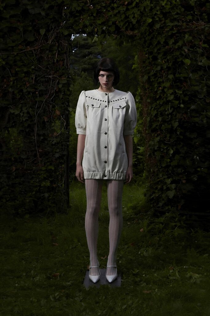 A fitted white dress with short sleeves, a collared neckline, and buttoned details.